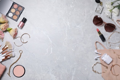 Photo of Flat lay composition with makeup products and accessories on light grey marble background. Space for text