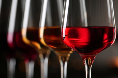 Photo of Row of glasses with different wines on blurred background, closeup