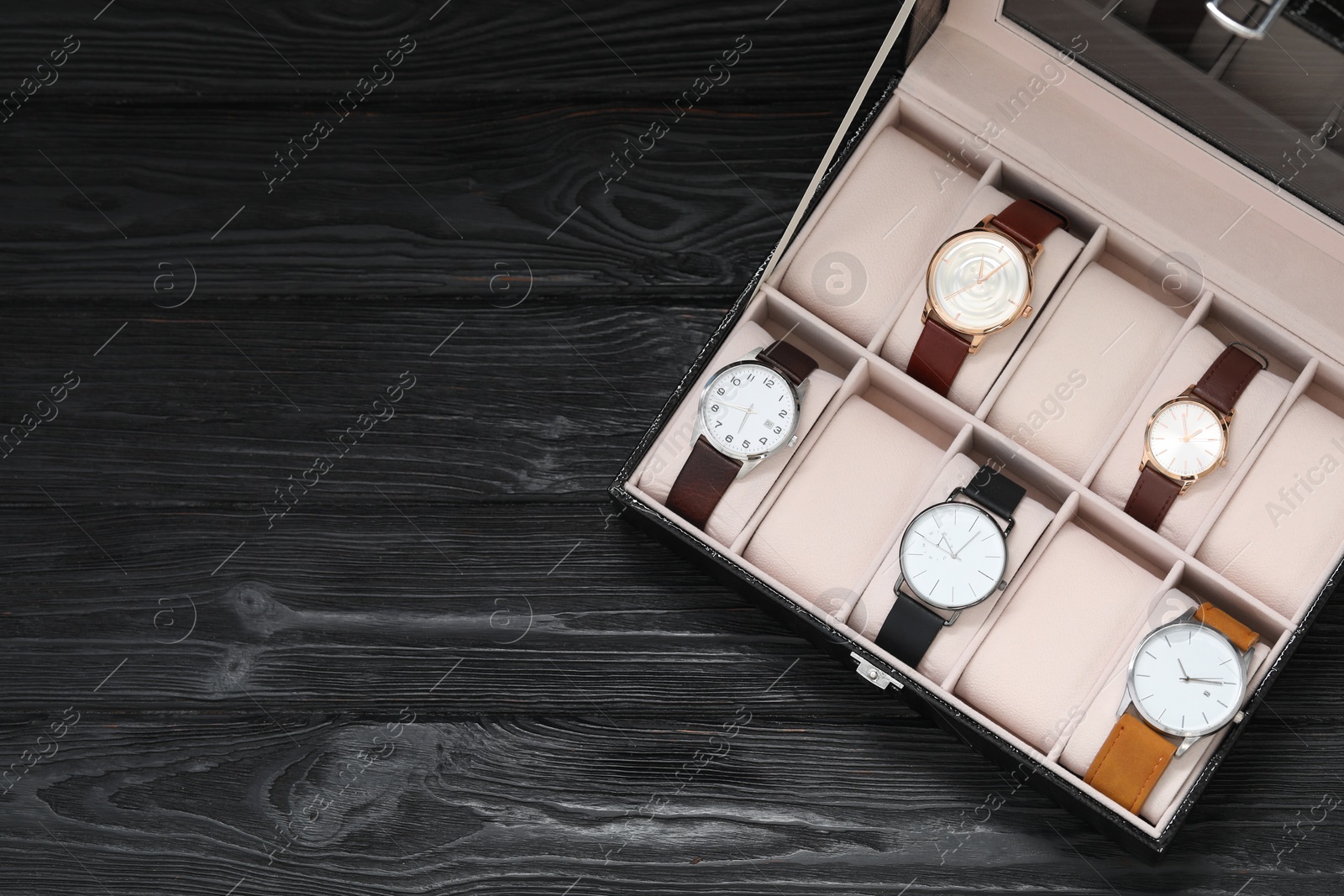 Photo of Jewelry box with many different accessories on black wooden table, top view. Space for text