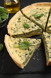 Photo of Cut delicious spinach served on slate plate