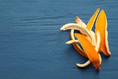 Photo of Orange peels preparing for drying on blue wooden table, flat lay. Space for text