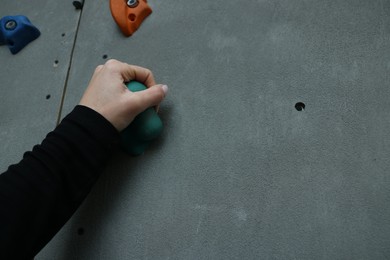 Woman climbing wall in gym, closeup. Extreme sport
