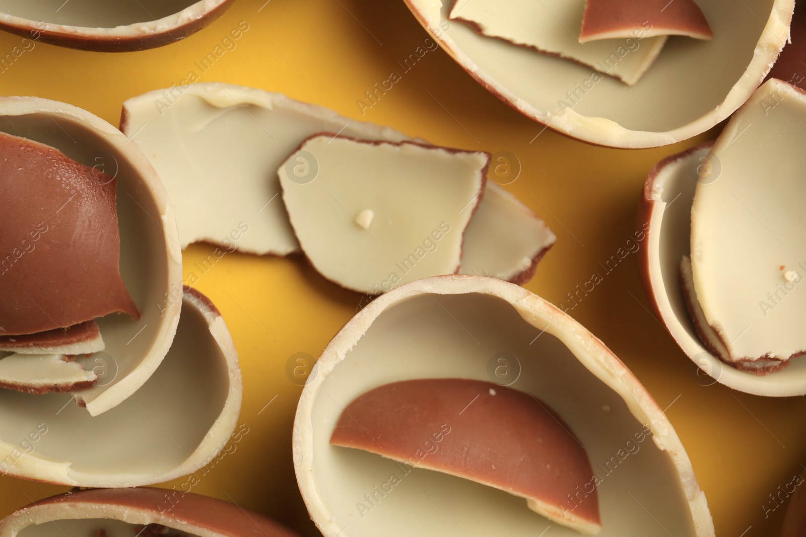 Photo of Sveti Vlas, Bulgaria - July 3, 2023: Broken halves of Kinder Surprise Eggs on yellow background, flat lay