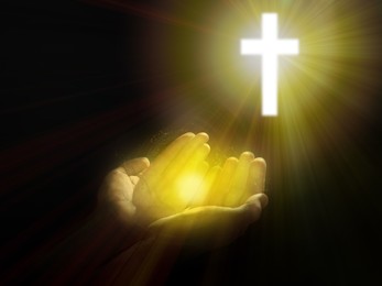 Image of Man stretching hands towards cross silhouette in darkness, closeup. Praying concept