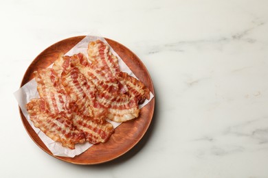 Photo of Delicious fried bacon slices on white marble table, top view. Space for text