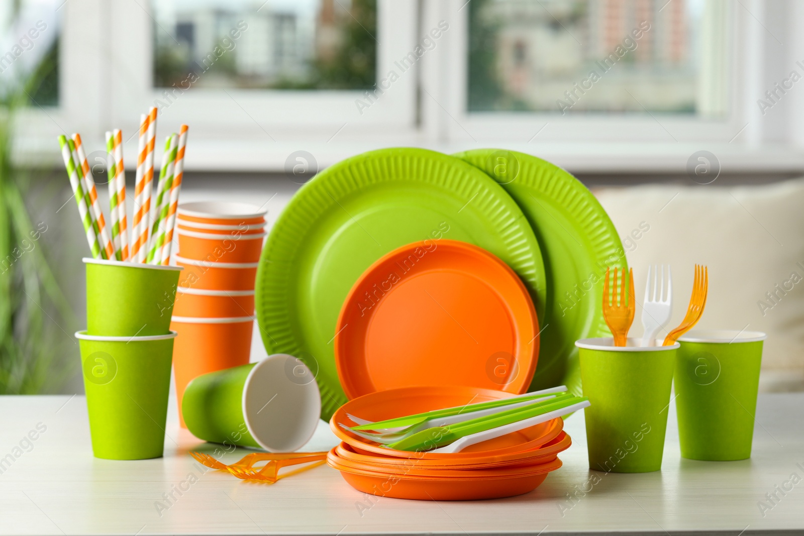 Photo of Set of disposable tableware on white wooden table indoors