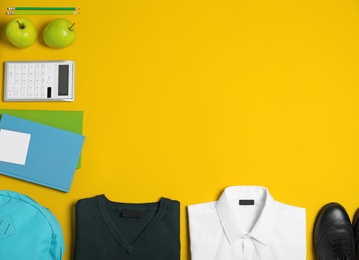 Photo of Flat lay composition with school uniform on yellow background. Space for text