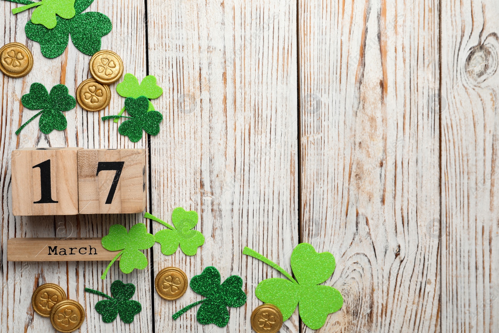 Photo of Flat lay composition with block calendar on white wooden background, space for text. St. Patrick's Day celebration