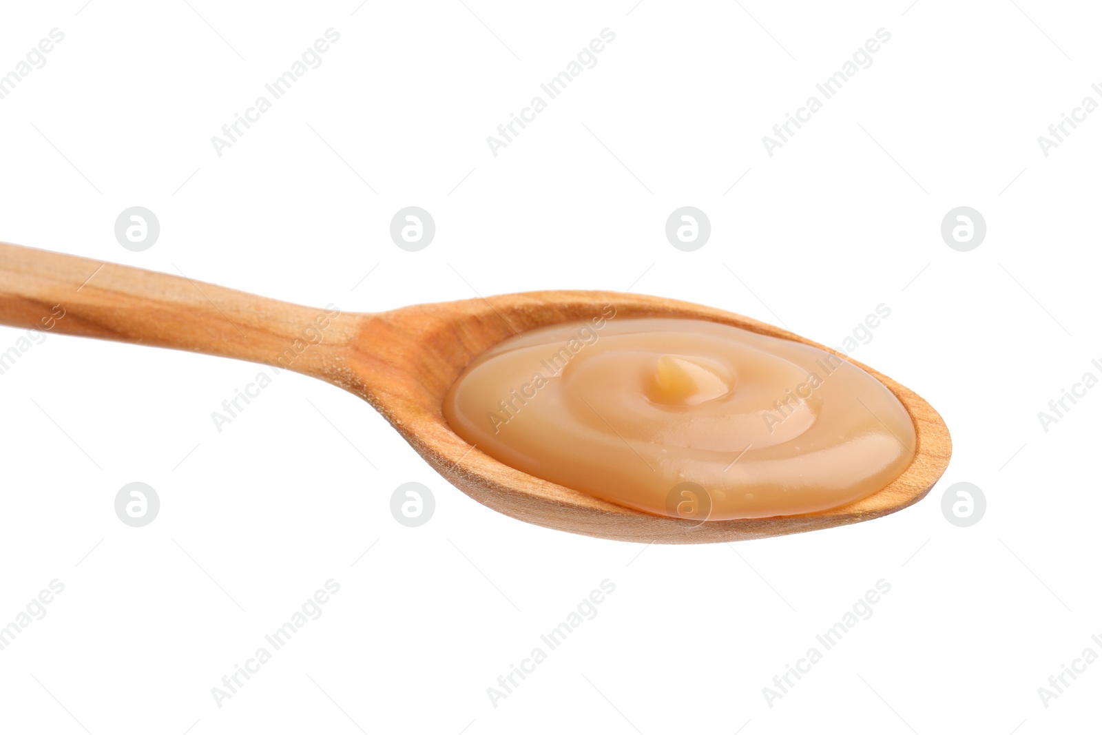Photo of Wooden spoon with tasty salted caramel isolated on white