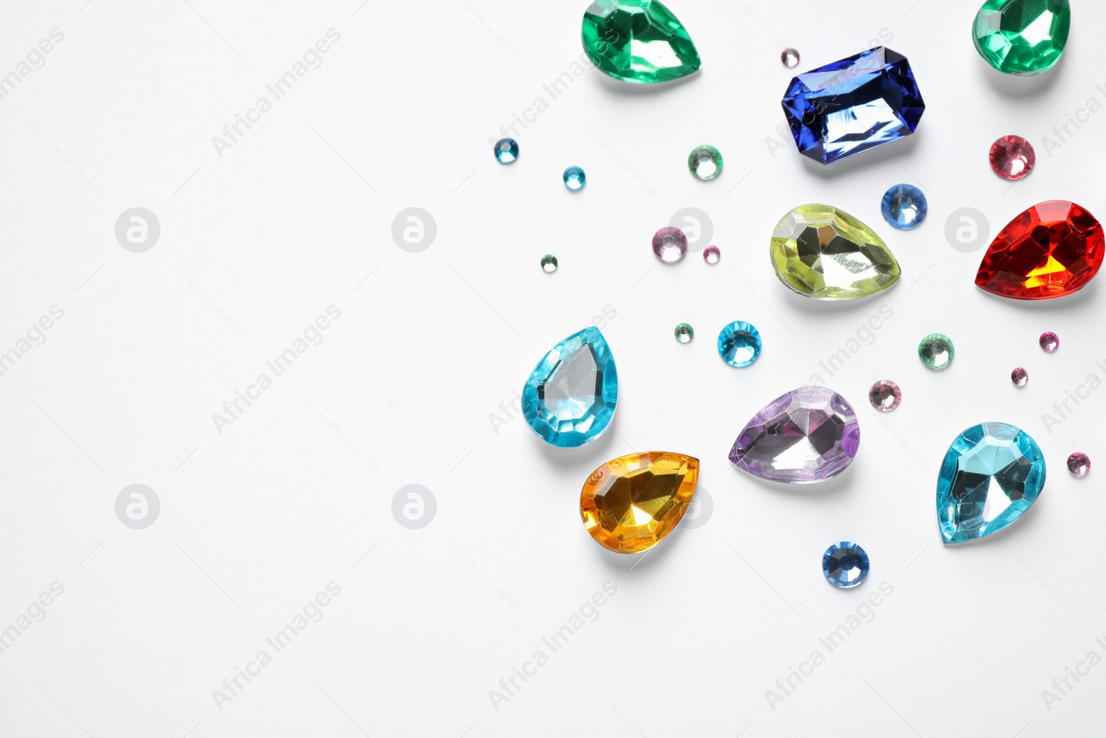 Photo of Different beautiful gemstones on white background, top view