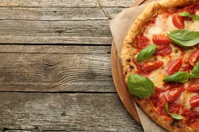 Photo of Delicious Margherita pizza on wooden table, top view. Space for text