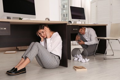 Photo of Scared employees hiding under office desks during earthquake