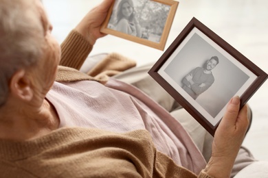 Elderly woman with framed photos at home