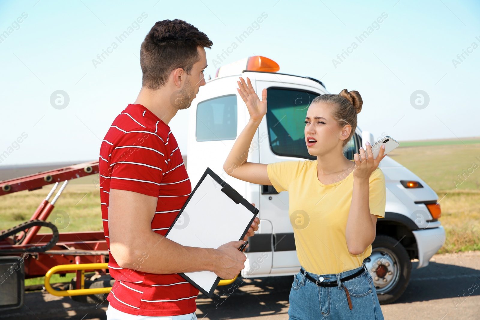 Photo of People near tow truck with broken car outdoors