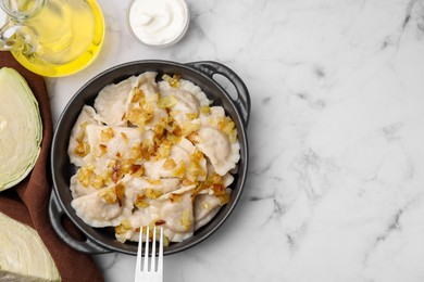 Photo of Cooked dumplings (varenyky) with tasty filling and fried onions on white marble table, flat lay. Space for text