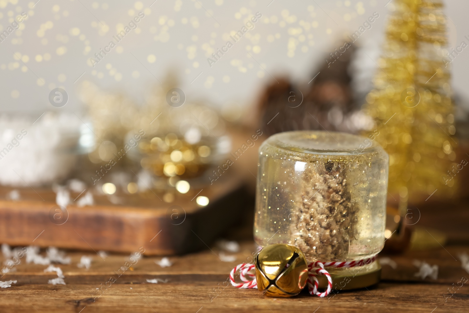 Photo of Handmade snow globe and Christmas decorations on wooden table, space for text