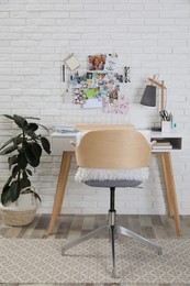 Photo of Stylish room interior with workplace and vision board