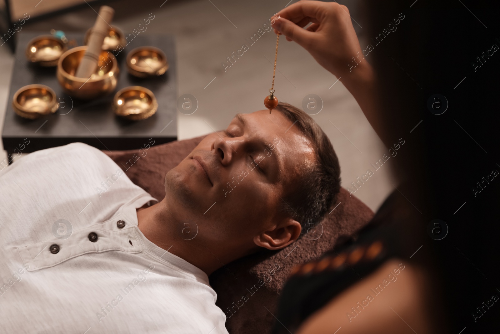 Photo of Man at crystal healing session in dark room