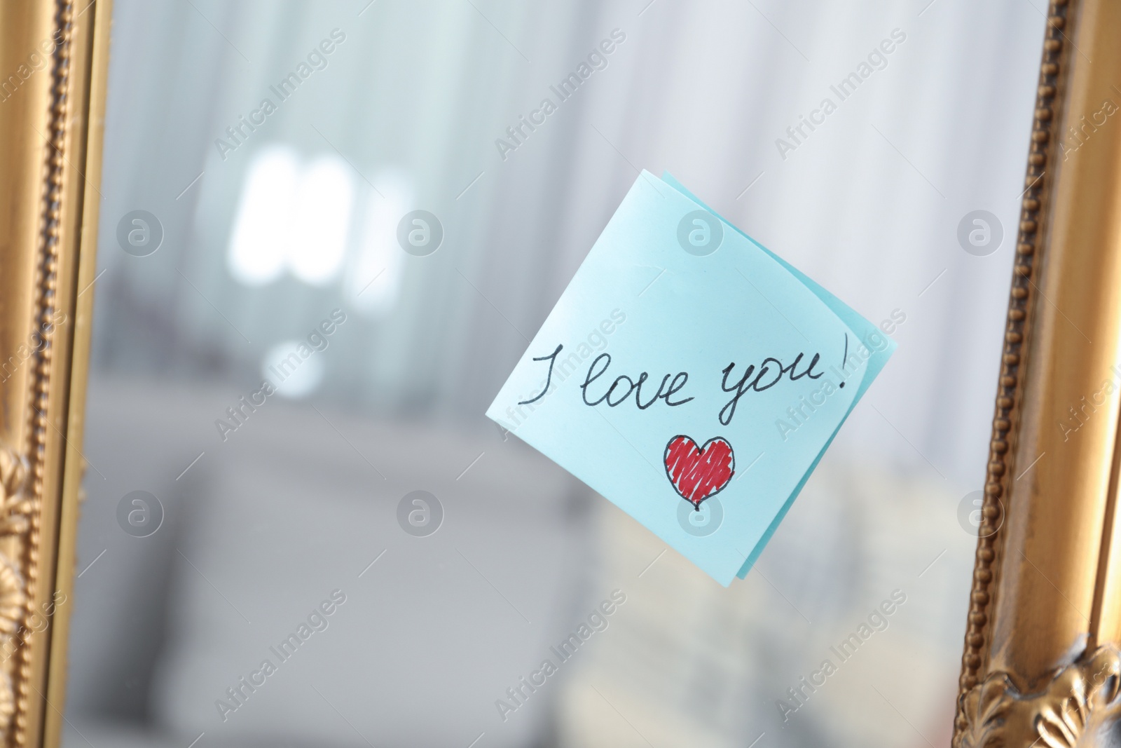 Photo of Note with phrase I Love You attached to mirror