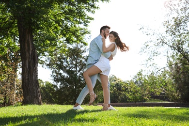 Photo of Lovely young couple dancing together in park on sunny day