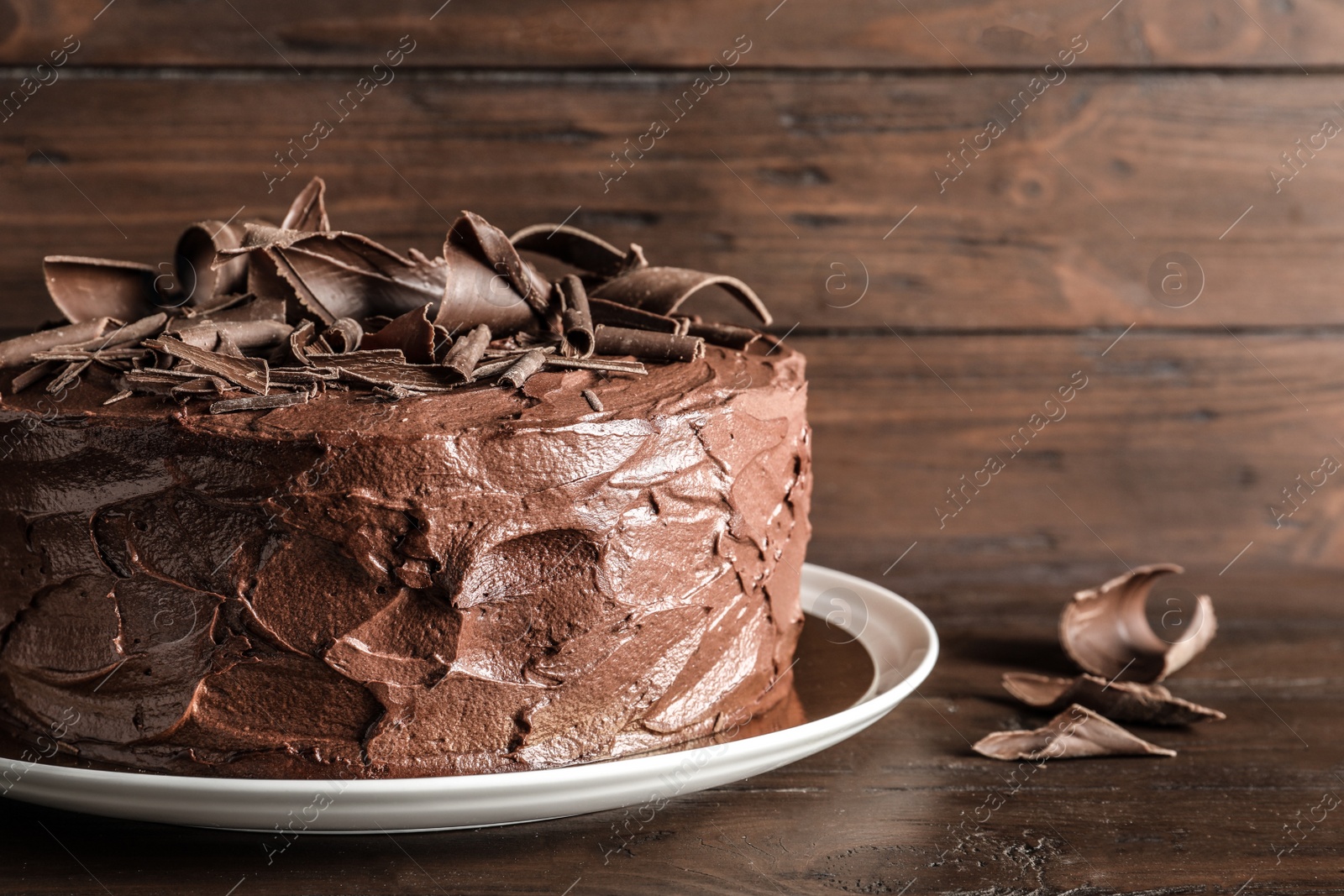 Photo of Plate with tasty homemade chocolate cake on wooden table