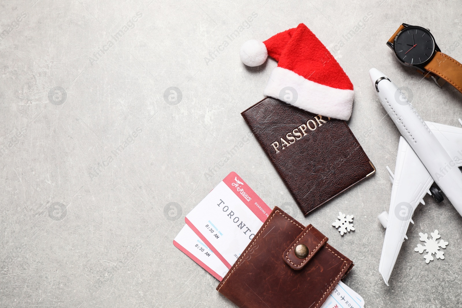 Photo of Flat lay composition with Santa hat and passport on light table, space for text. Christmas vacation