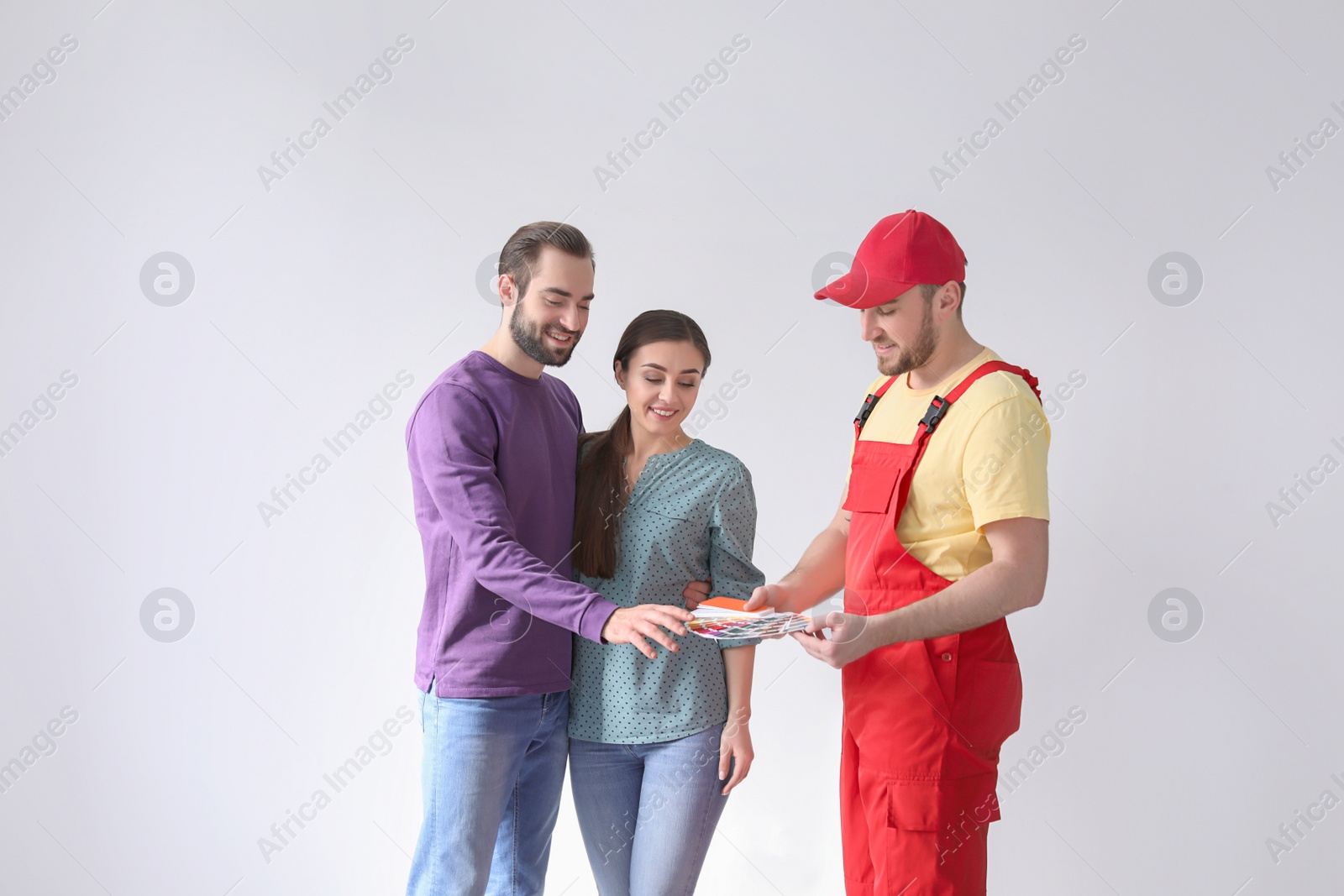 Photo of Male decorator and young couple with color palette on white background