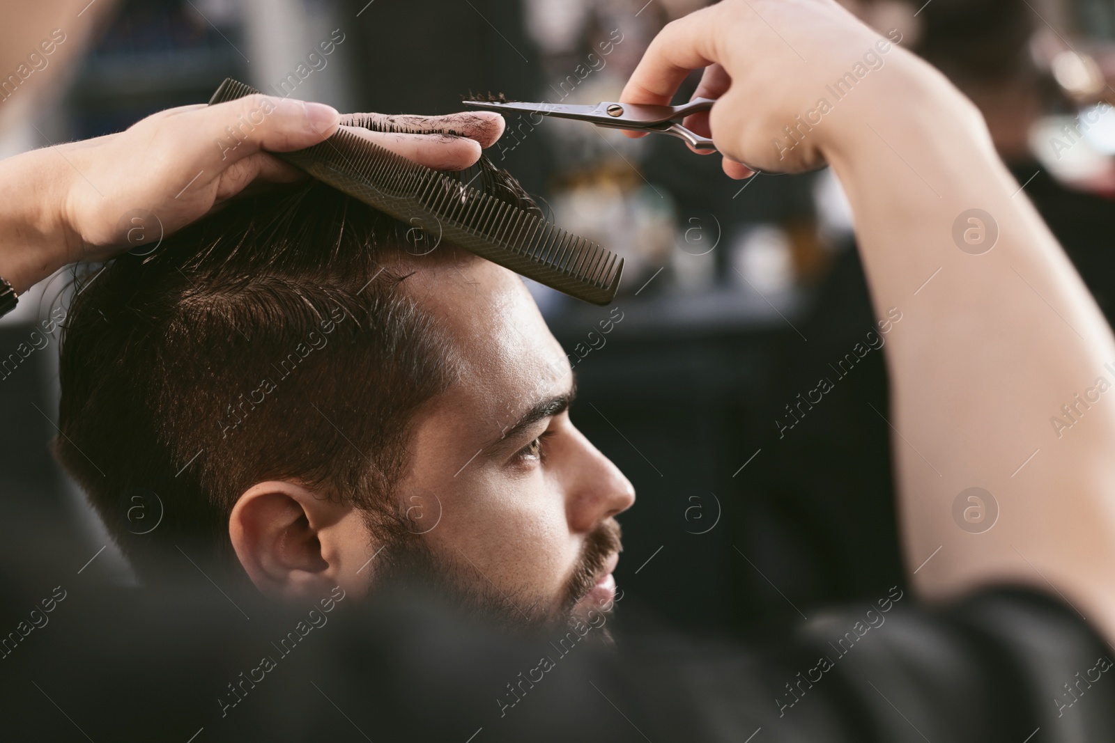 Image of Professional hairdresser working with bearded client in barbershop