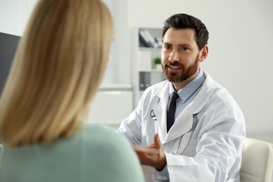 Photo of Doctor consulting patient at workplace in clinic