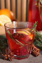Aromatic punch drink and fir tree branch on wooden table, closeup