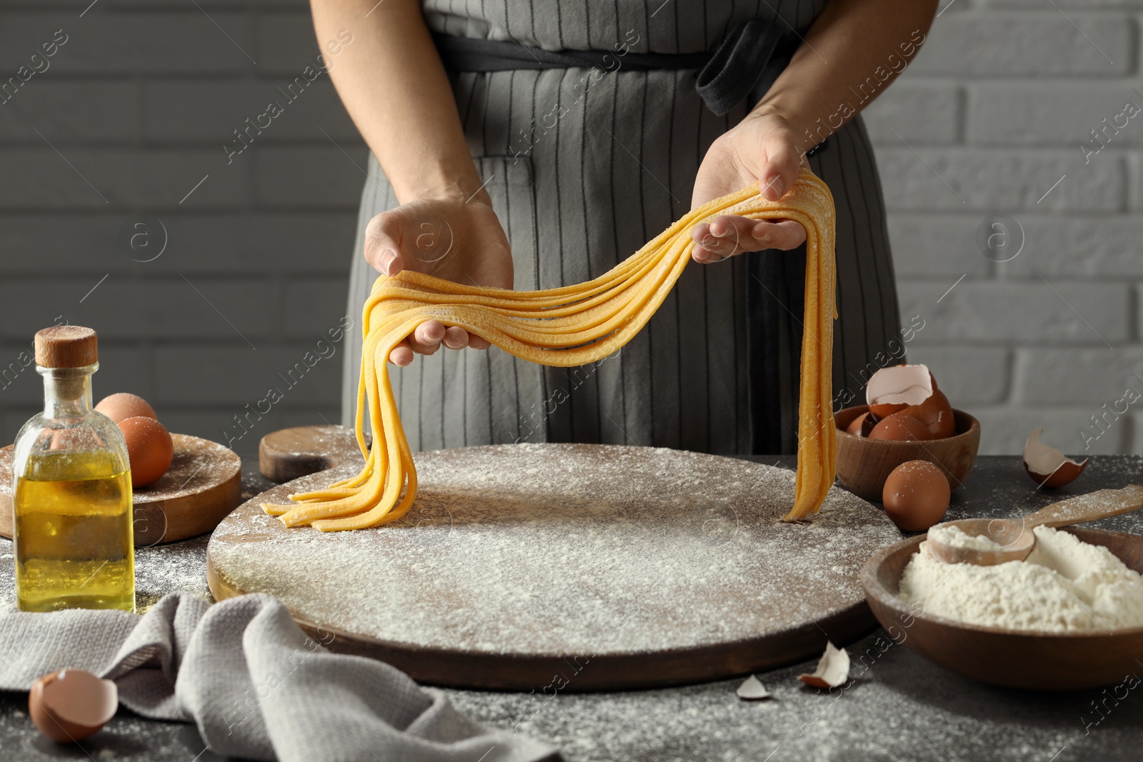 Photo of Woman making homemade pasta at table, closeup