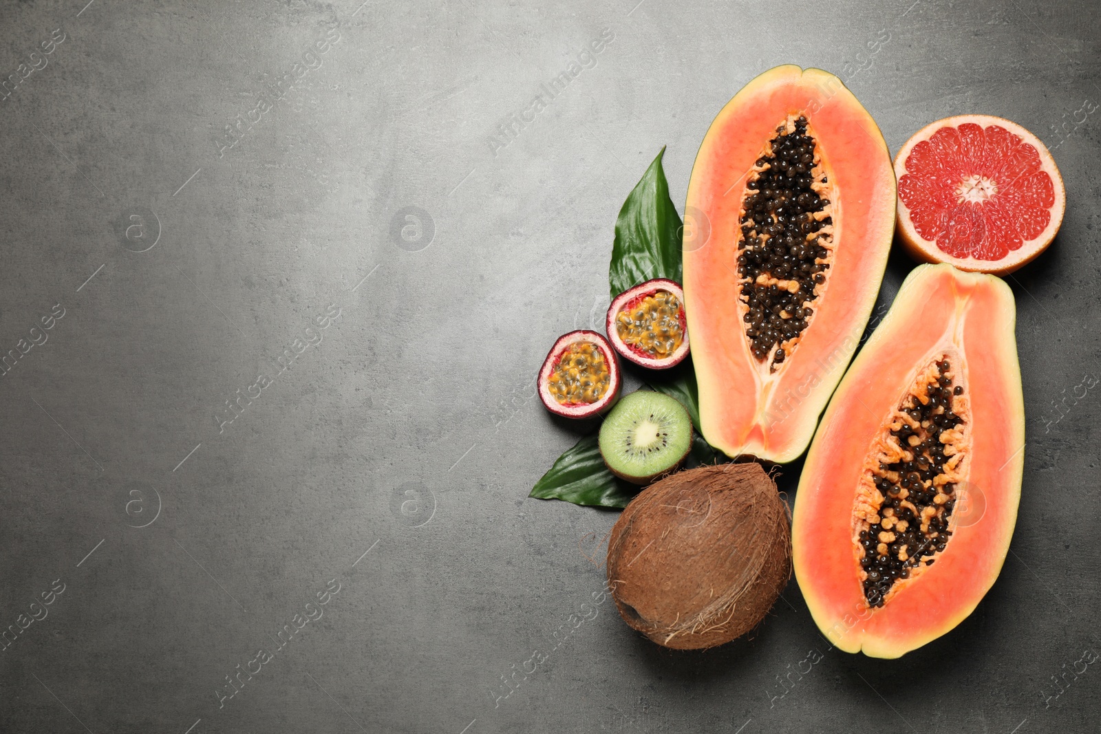 Photo of Fresh ripe papaya and other fruits on grey table, flat lay. Space for text