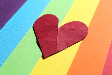 Red crumpled paper heart on colorful background. Breakup concept