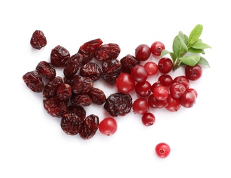 Photo of Tasty fresh and dried cranberries with leaves on white background, top view