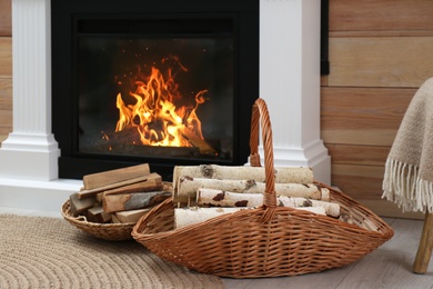 Firewood in wicker baskets near fireplace indoors