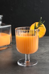 Delicious tangerine liqueur in glass on grey table