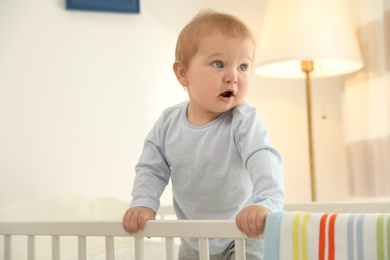 Cute little baby in crib at home