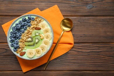 Tasty smoothie bowl with fresh fruits and oatmeal served on wooden table, flat lay. Space for text