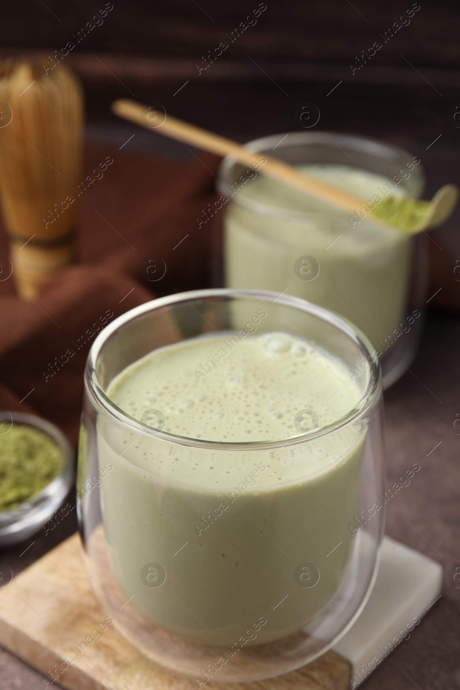 Photo of Glass of tasty matcha smoothie on brown table, closeup. Space for text