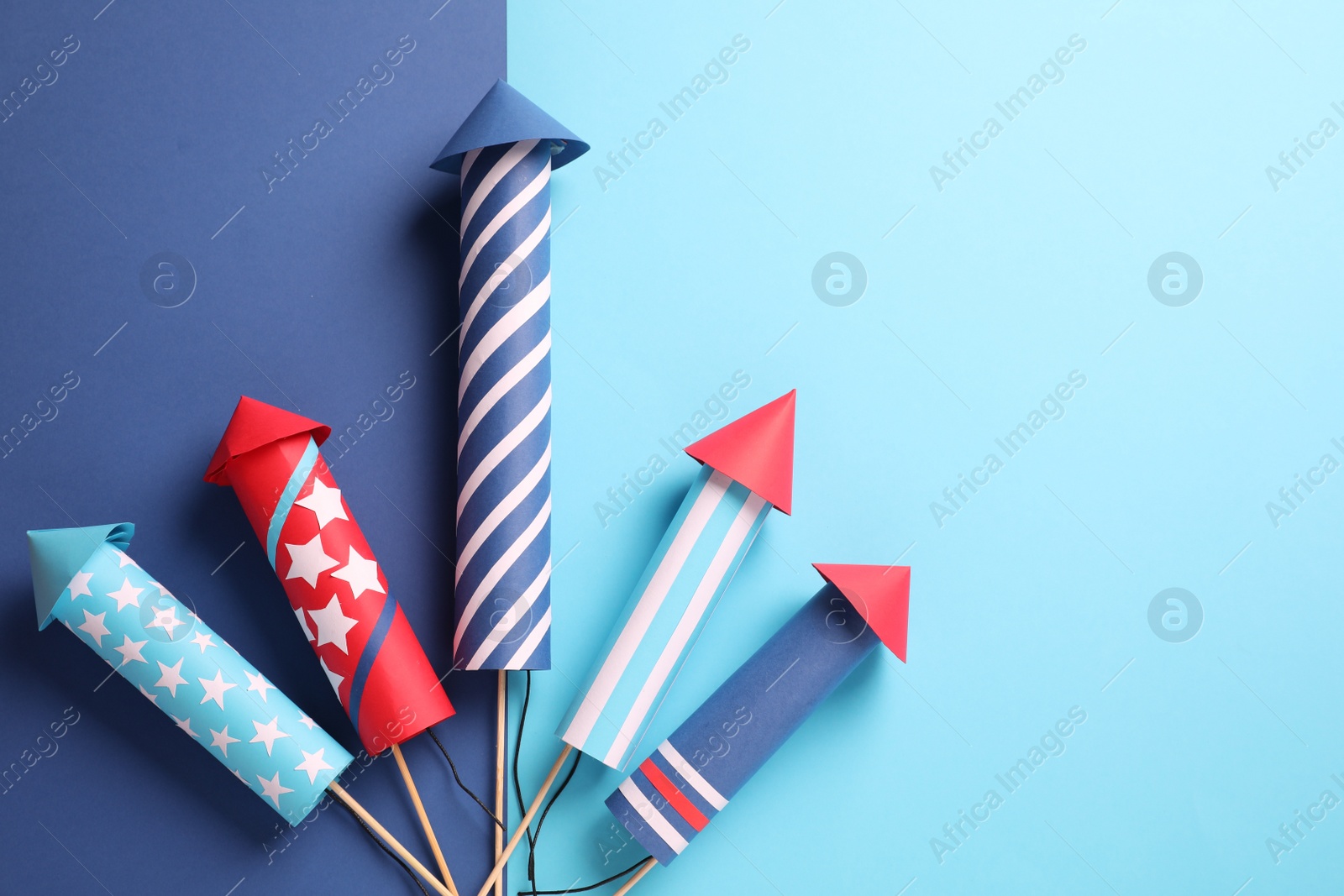 Photo of Firework rockets on color background, flat lay. Space for text