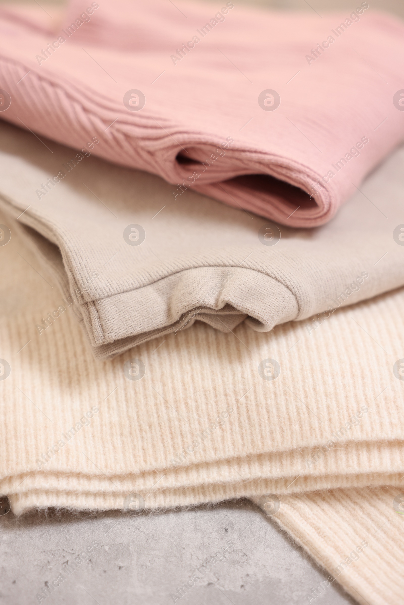 Photo of Stack of folded clothes on grey table, closeup