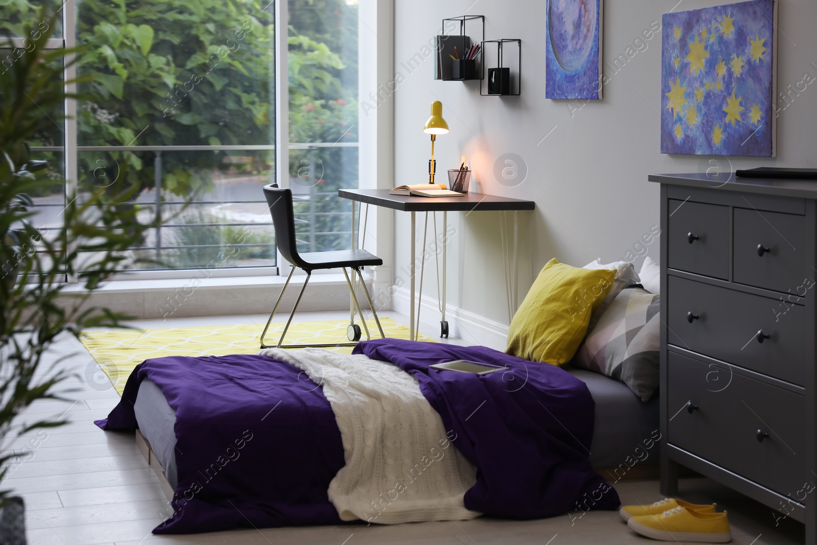 Photo of Modern teenager's room interior with comfortable bed, workplace and stylish design elements