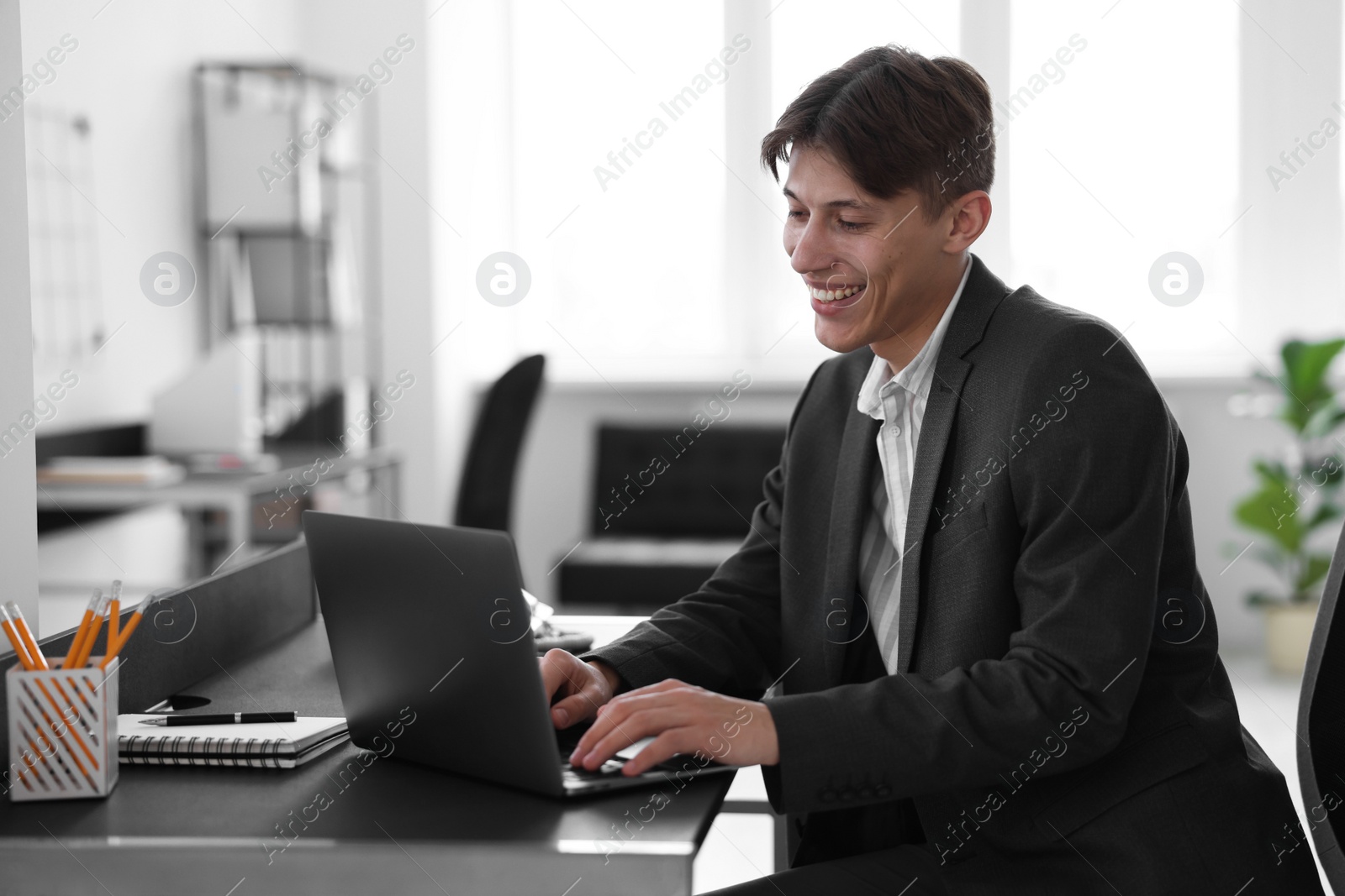 Photo of Man watching webinar at table in office