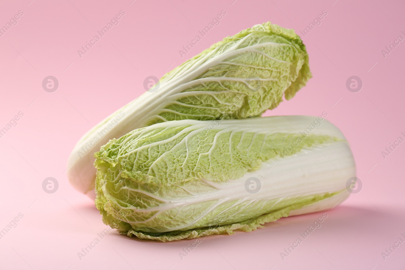 Photo of Fresh ripe Chinese cabbages on pink background