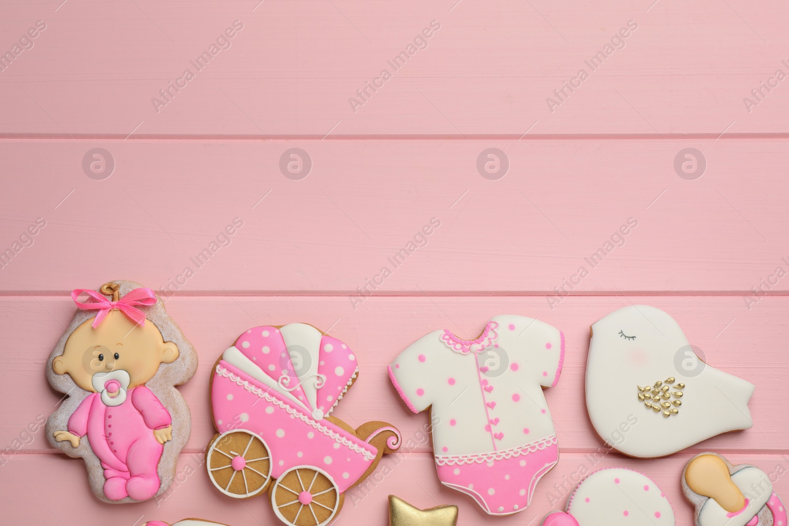 Photo of Cute tasty cookies of different shapes and space for text on pink wooden table, flat lay. Baby shower party