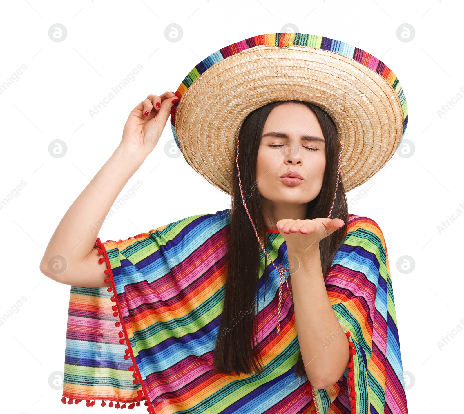 Photo of Young woman in Mexican sombrero hat and poncho blowing kiss on white background