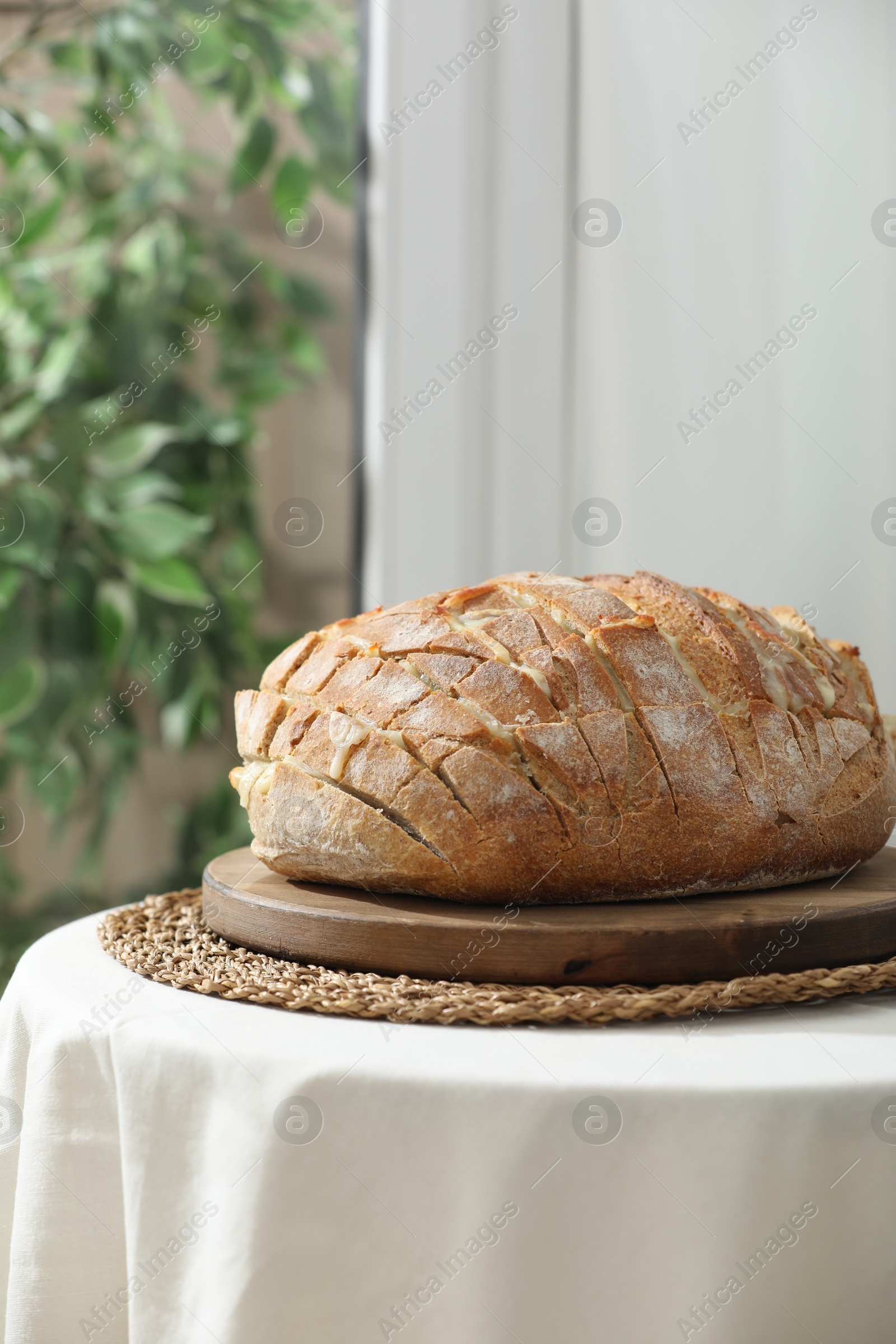 Photo of Freshly baked bread with tofu cheese on table indoors