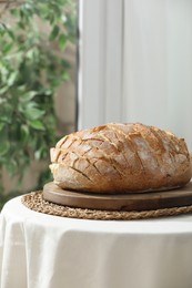 Photo of Freshly baked bread with tofu cheese on table indoors