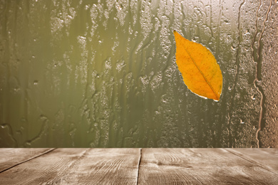 Wooden table near window on rainy day