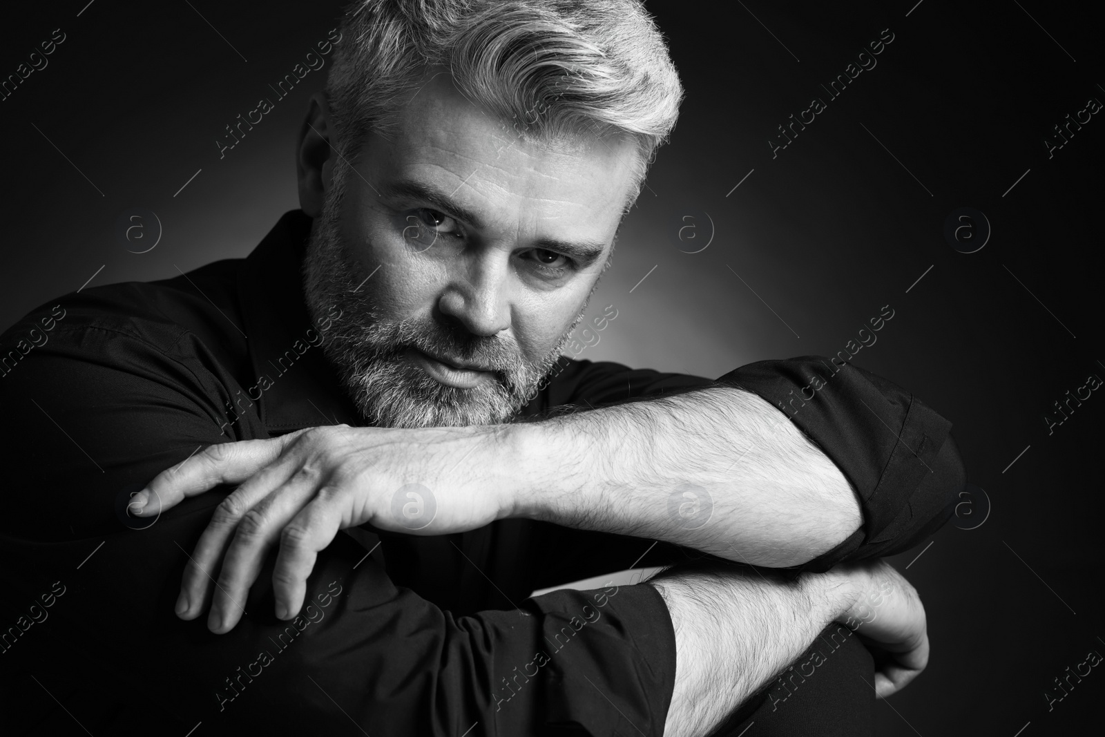 Photo of Portrait of handsome man on dark background. Black and white effect